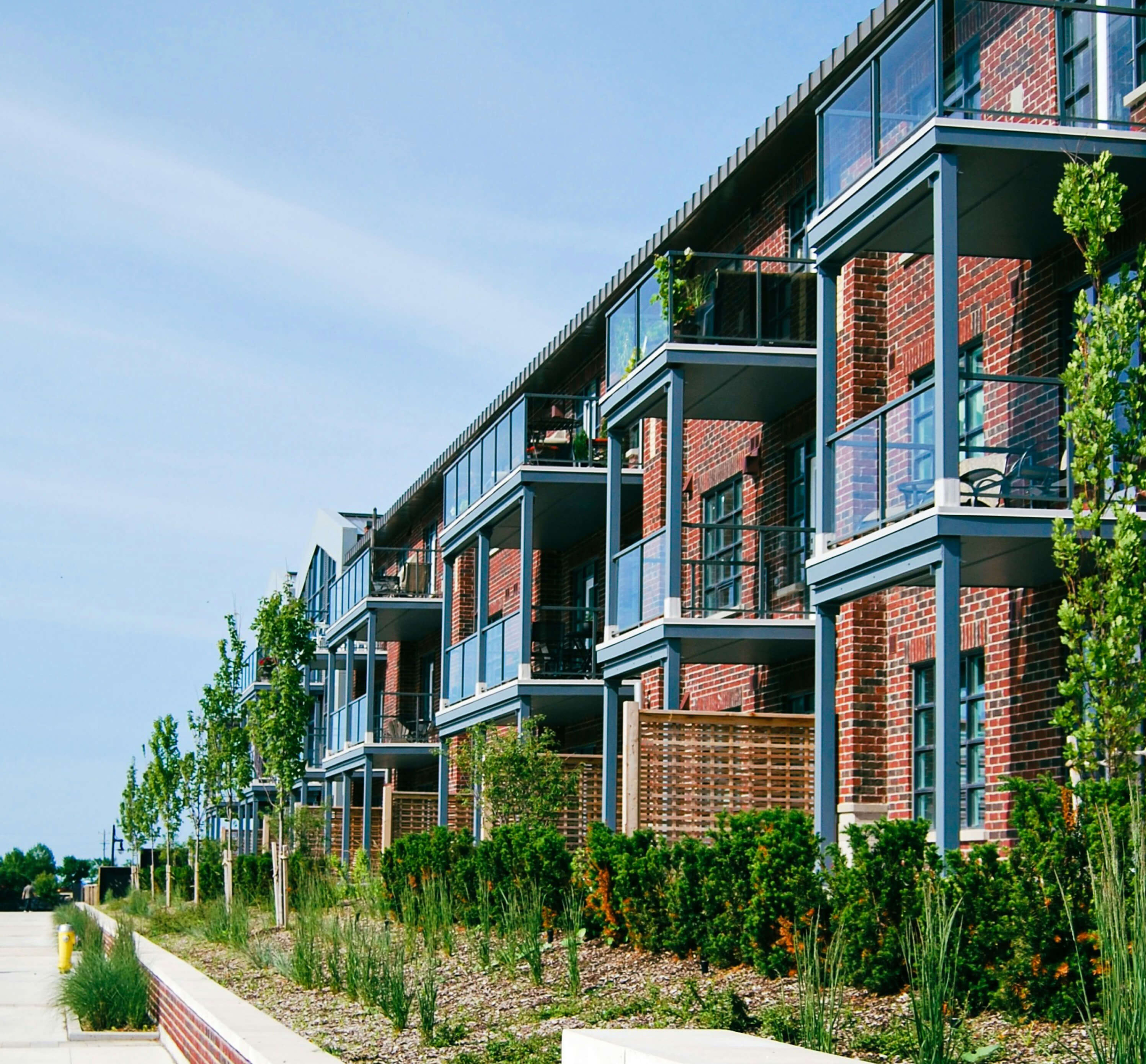 A building with balconies and plants, supported by the Lancaster Housing Fund, offers affordable housing in a welcoming green environment.